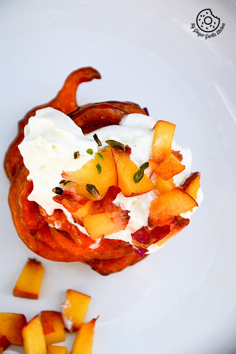 a plate of instant peach jalebi with peaches and whipped cream on it
