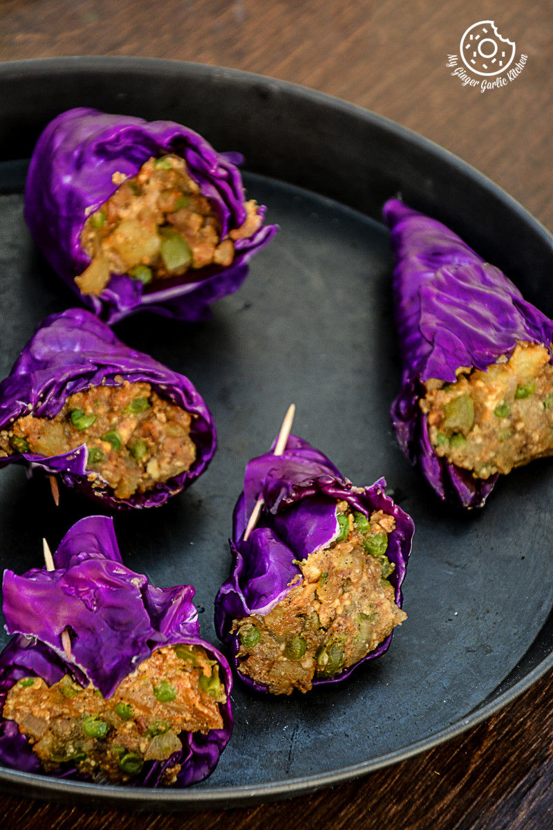 purple cabbage rolls on a plate with toothpicks in them