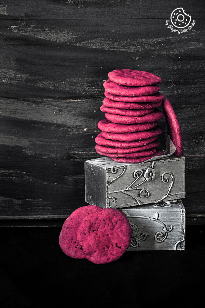 a stack of a stack of pink baked beet mathri sitting on top of a box