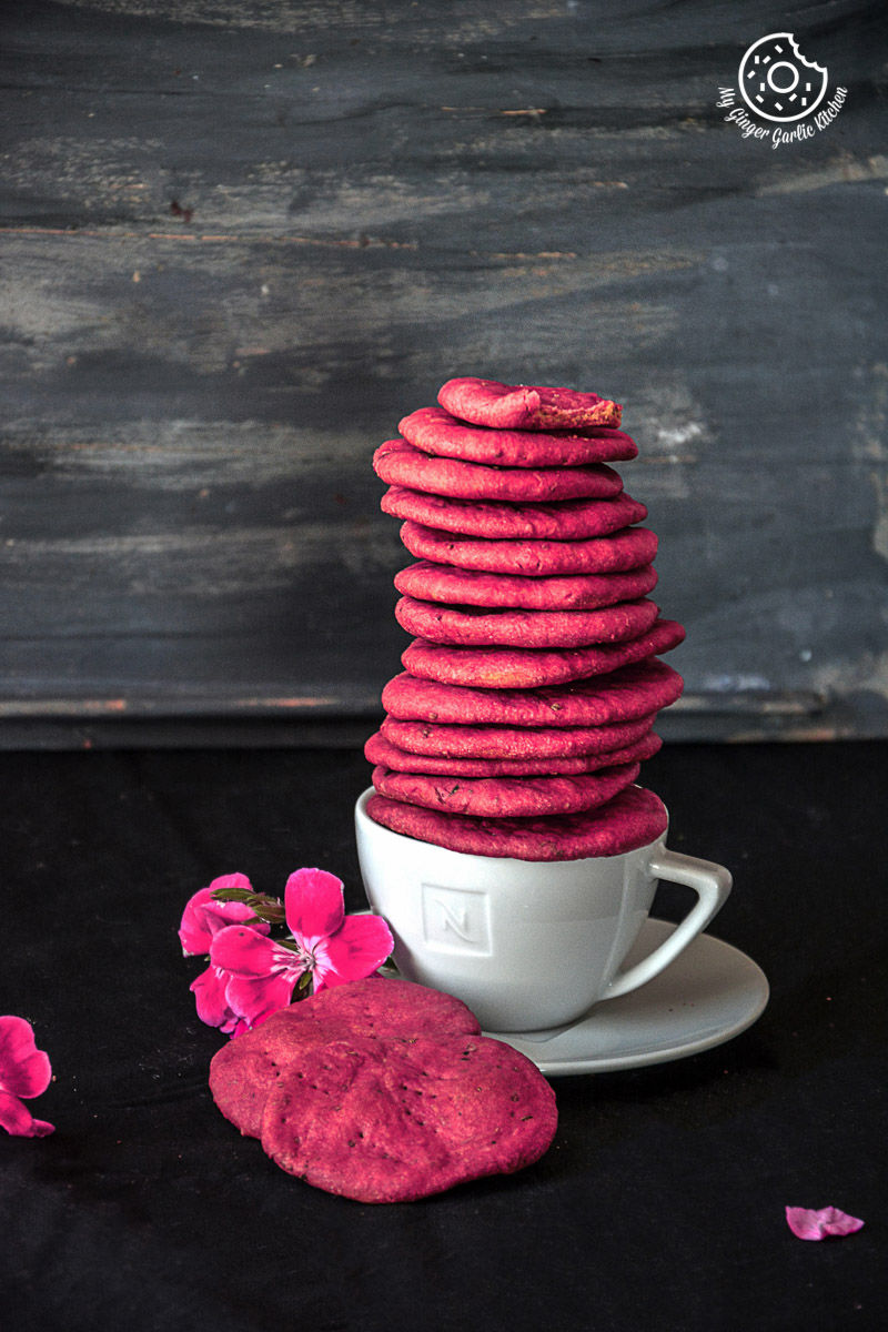 a stack of pink baked beet mathri sitting on a plate in a cup