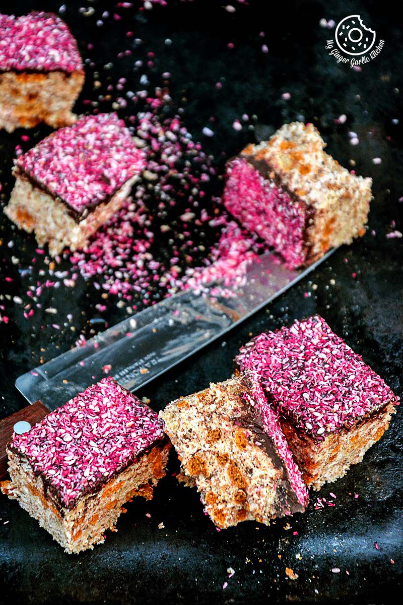a bunch of pink and white toasted coconut sesame rice krispie and multigrain cheerios dark chocolate bars on a black surface