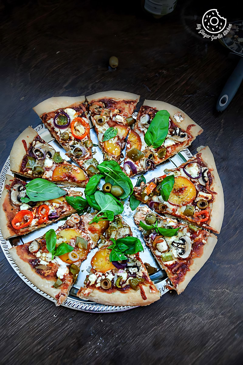a wholewheat peach mushroom pizza with feta and fresh basil with a slice missing from it on a plate