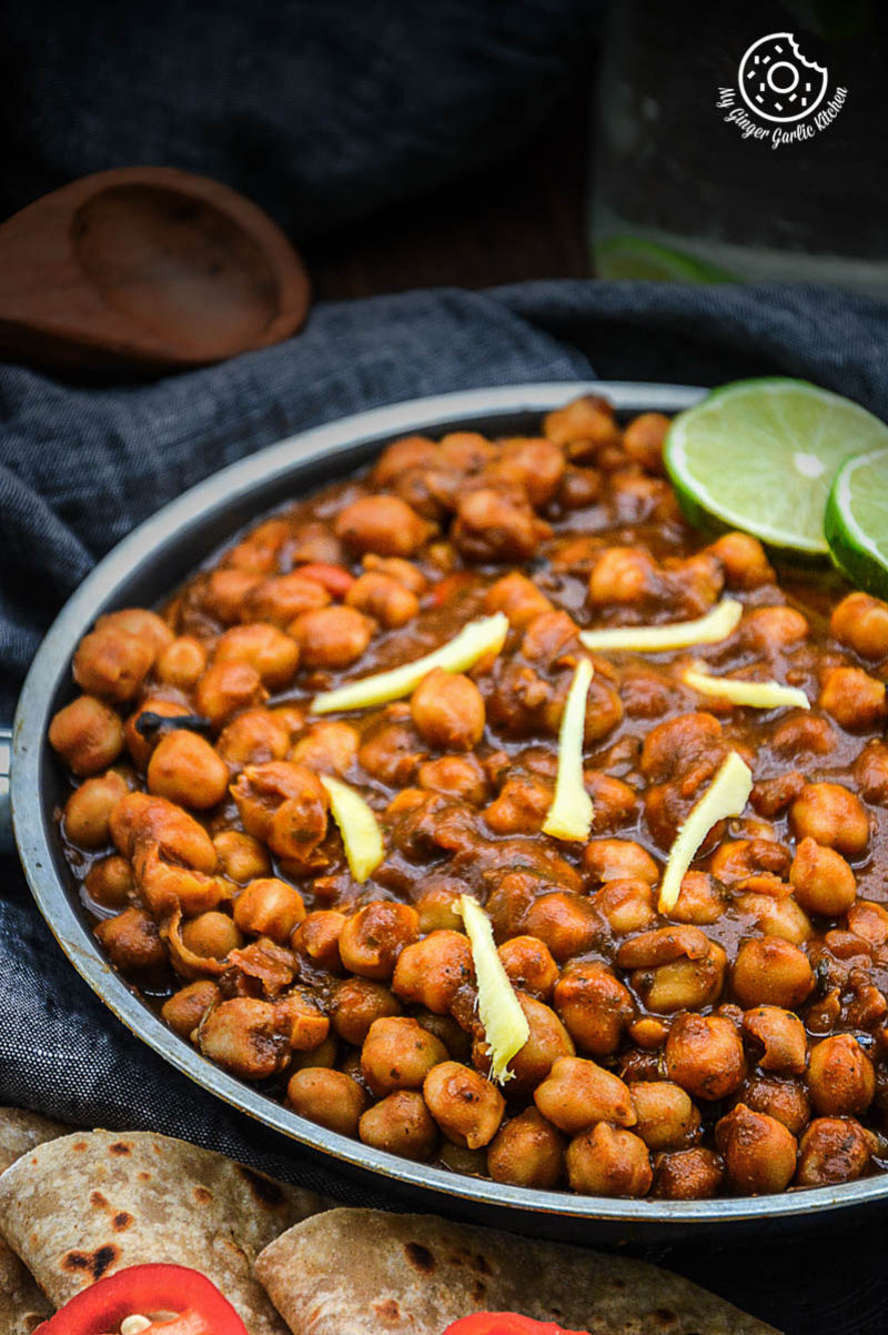  a plate of amritsari chole with two lime slices
