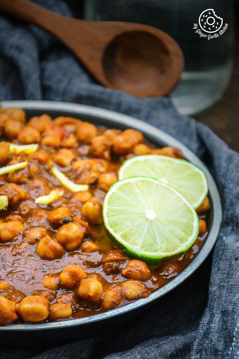 a plate of amritsari chole with a lime slice on top