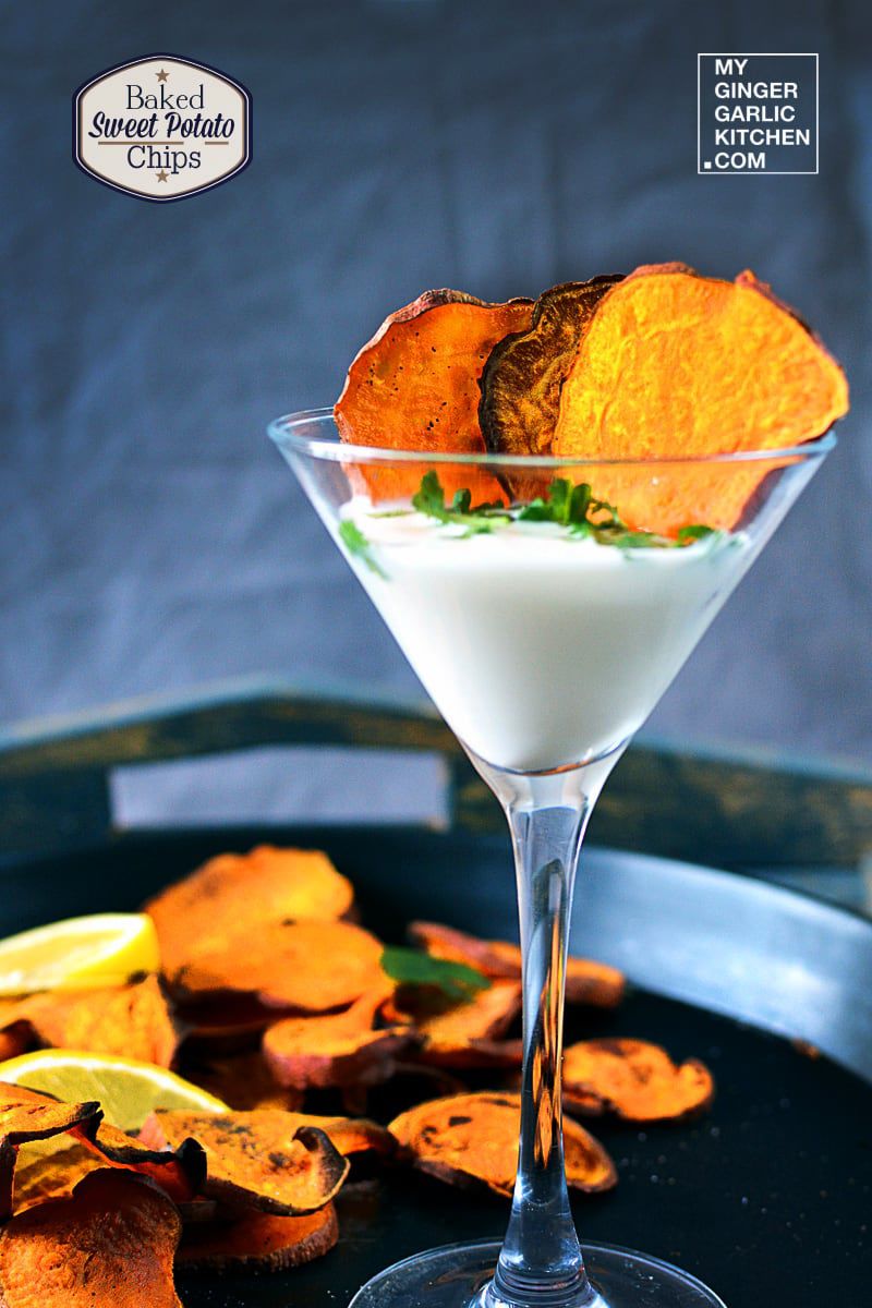 a martini glass with a dip and baked sweet potato chips in it