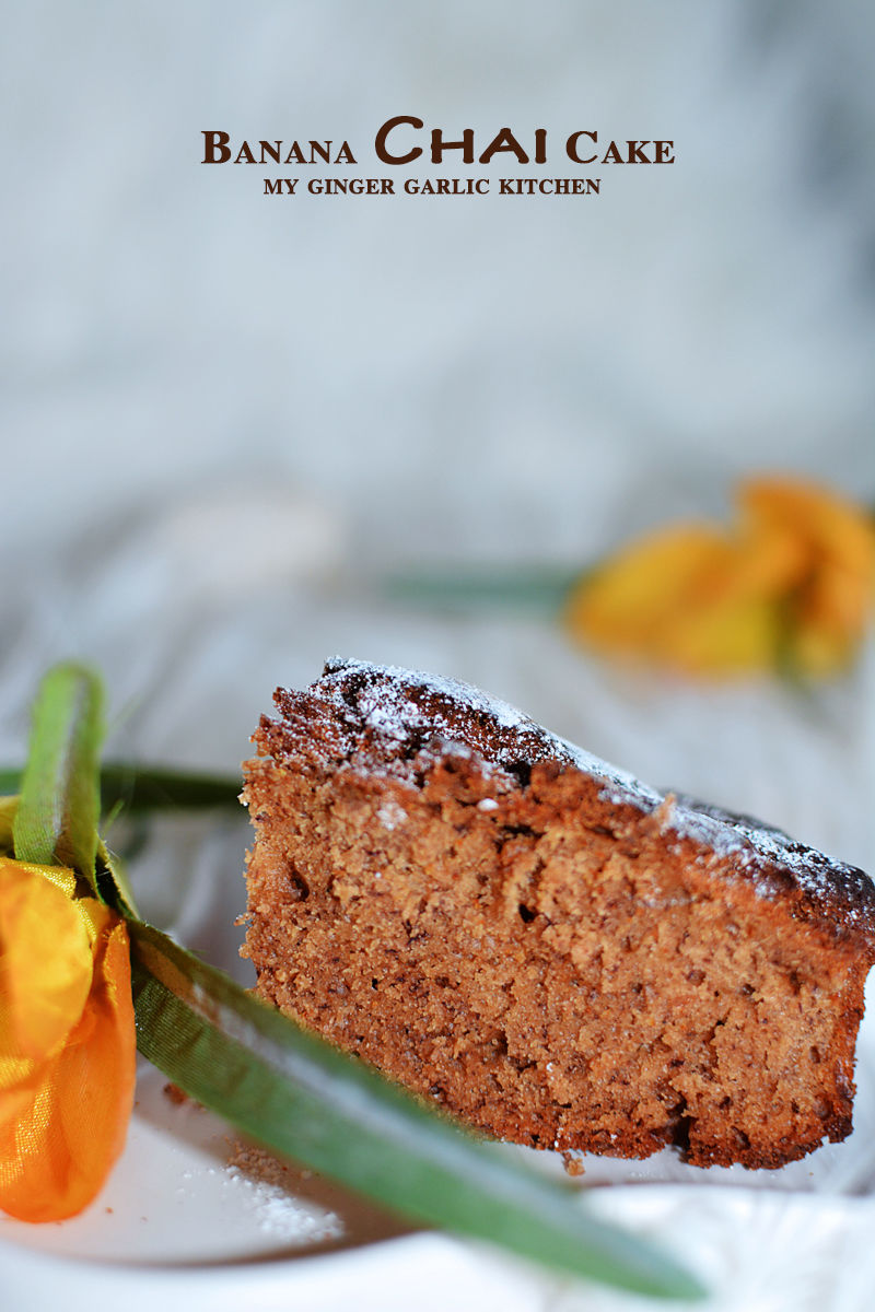 a piece of banana chai cake on a plate with a flower