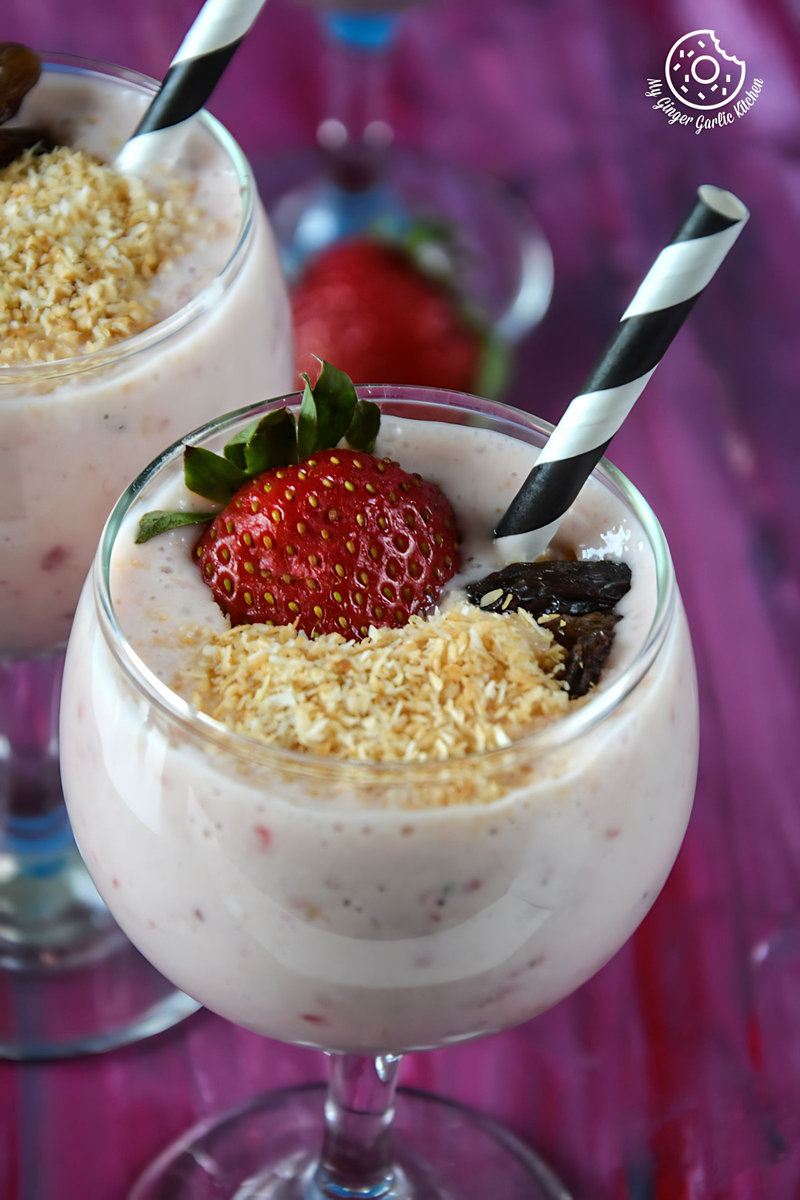 two glasses of banana strawberry coconut smoothie with strawberries and chocolate