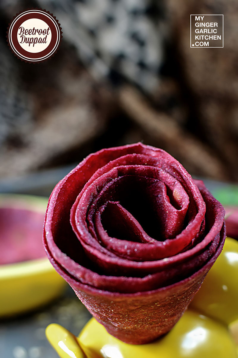 beetroot duppad roti rolled in a flower shape is sitting on a yellow plate