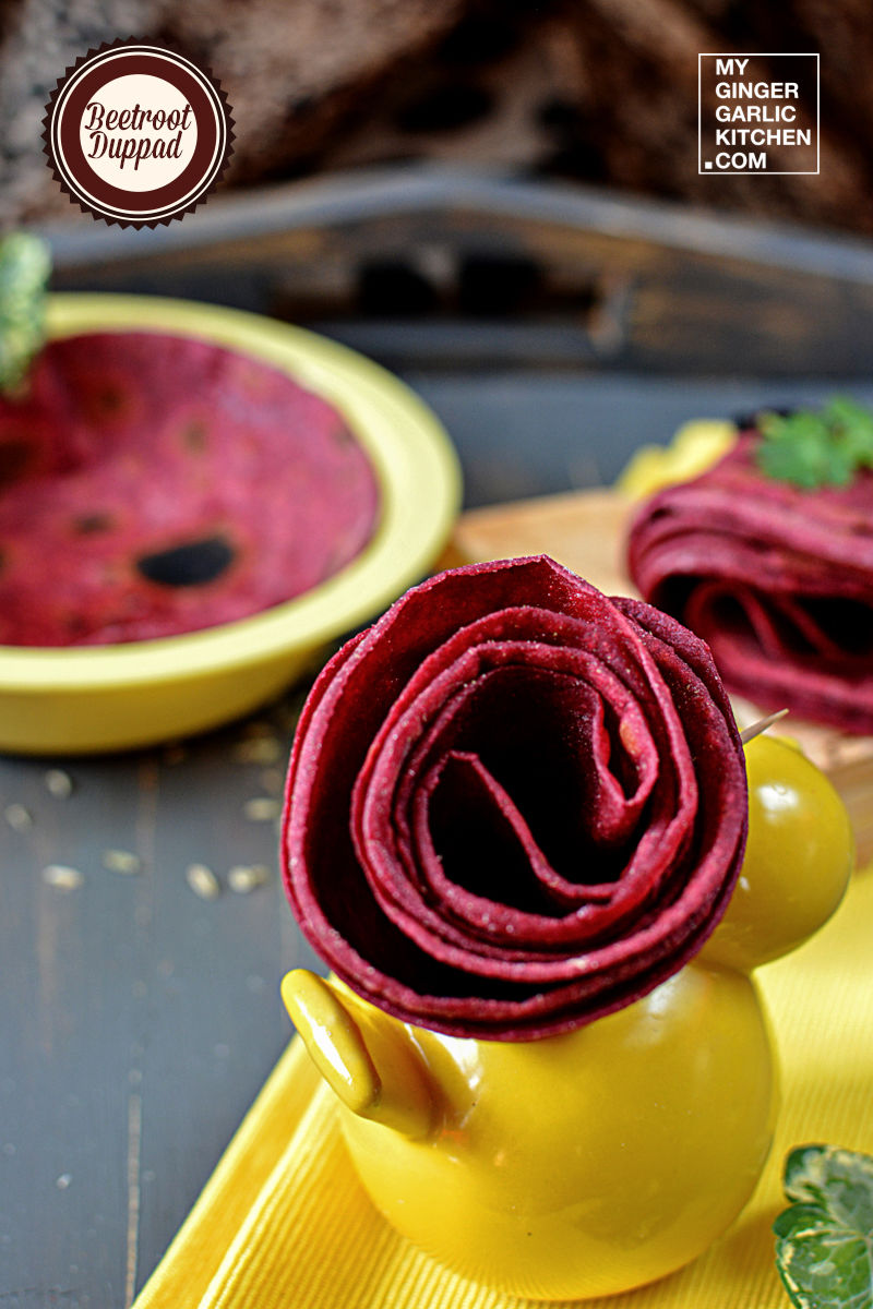 yellow vase with beetroot duppad roti rolled in a flower shape on a yellow napkin