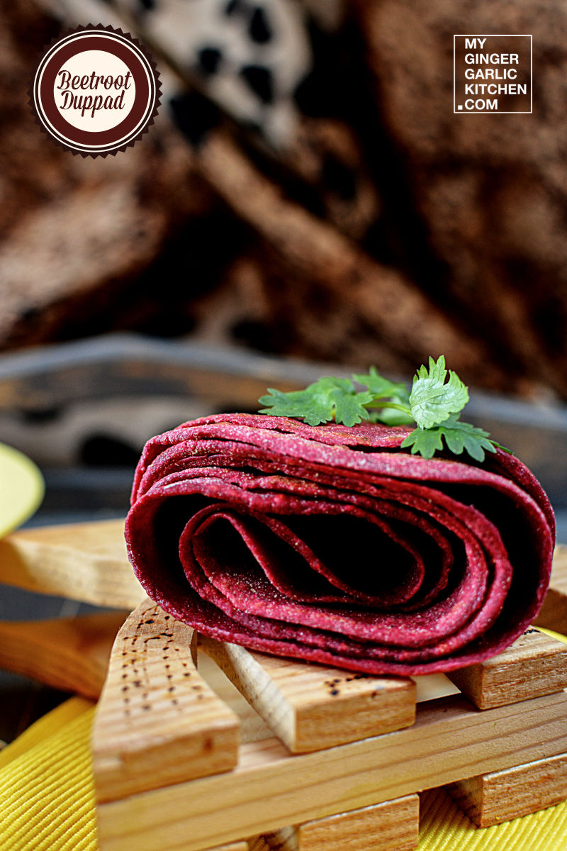 a rolled beetroot duppad roti rolled  on a wooden tray