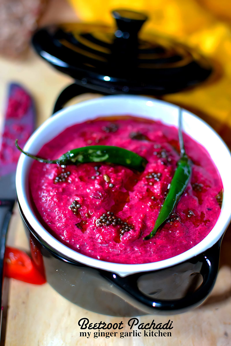 a bowl of kerala style beetroot pachadi with a green chili in it