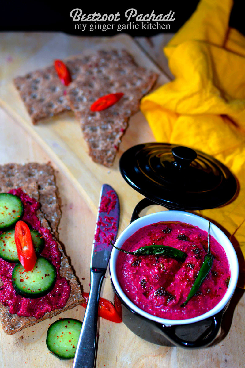 a bowl of beetroot pachadi and crackers and a yellow napkin