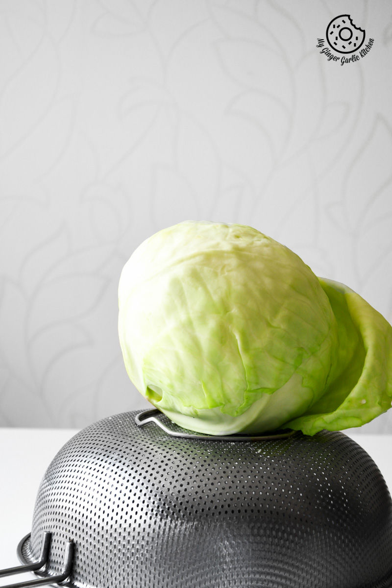 a cabbage on top of a black strainer