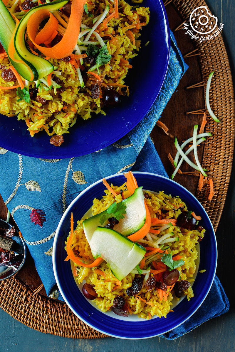 two bowls of carrot zuchinni pilaf on a blue plate on a table