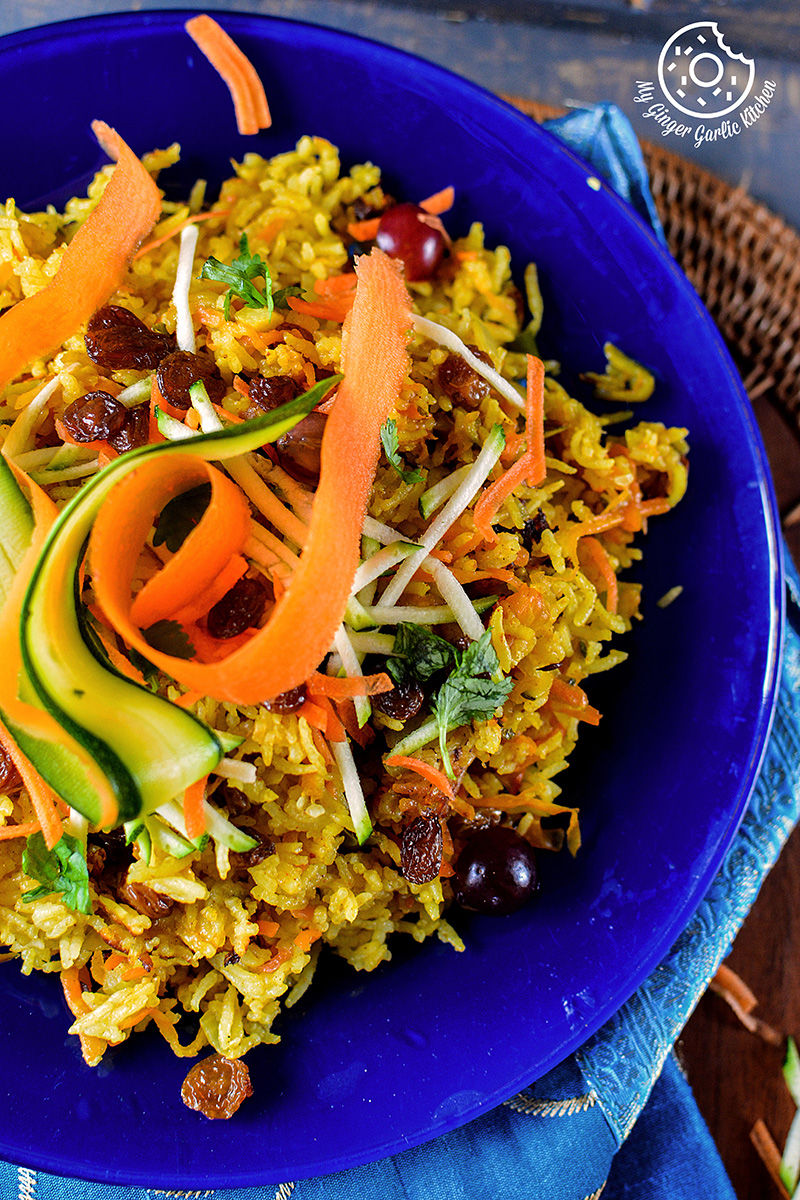 a blue plate with a carrot zuchinni pilaf on it on a table