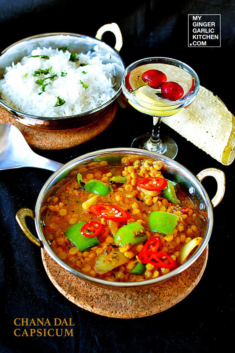 a bowl of chana dal capsicum curry with rice and a glass of water