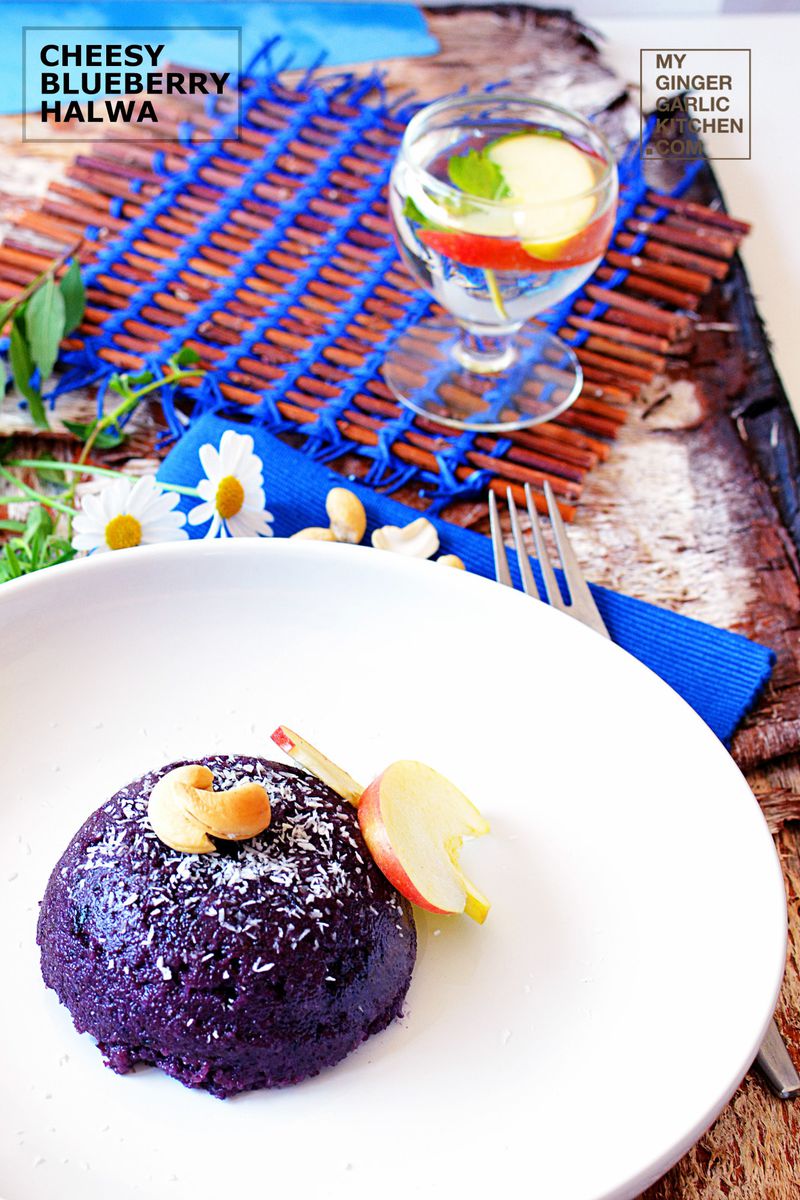 a plate of cheesy blueberry halwa on a table with a blue place mat