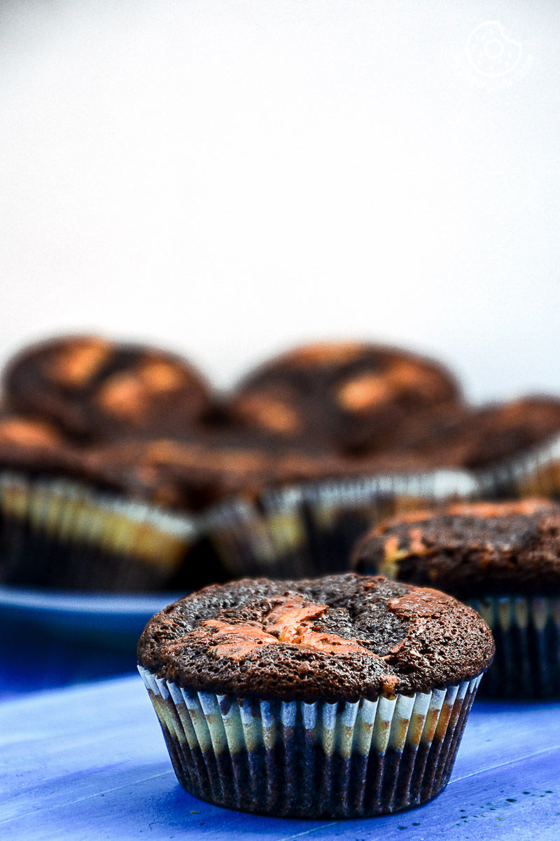 a lot of chocolate cream cheese muffins on a blue table
