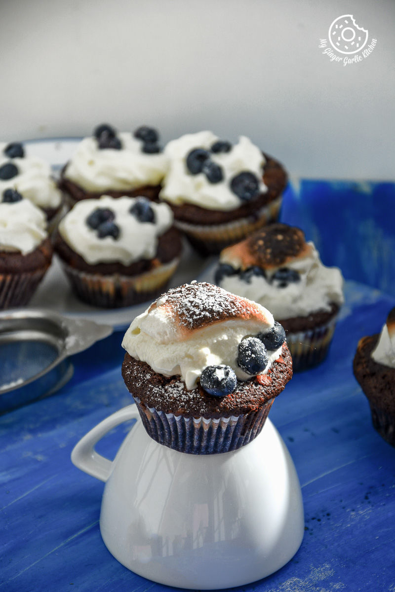 chocolate cream cheese muffin with blueberries with marshmallow on top of them