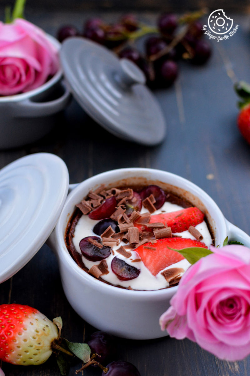 a bowl of chocolate pots de creme with strawberries and cherries