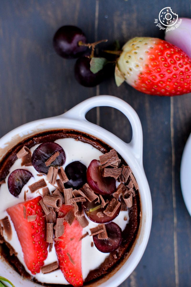 a bowl of chocolate pots de creme with strawberries and chocolate