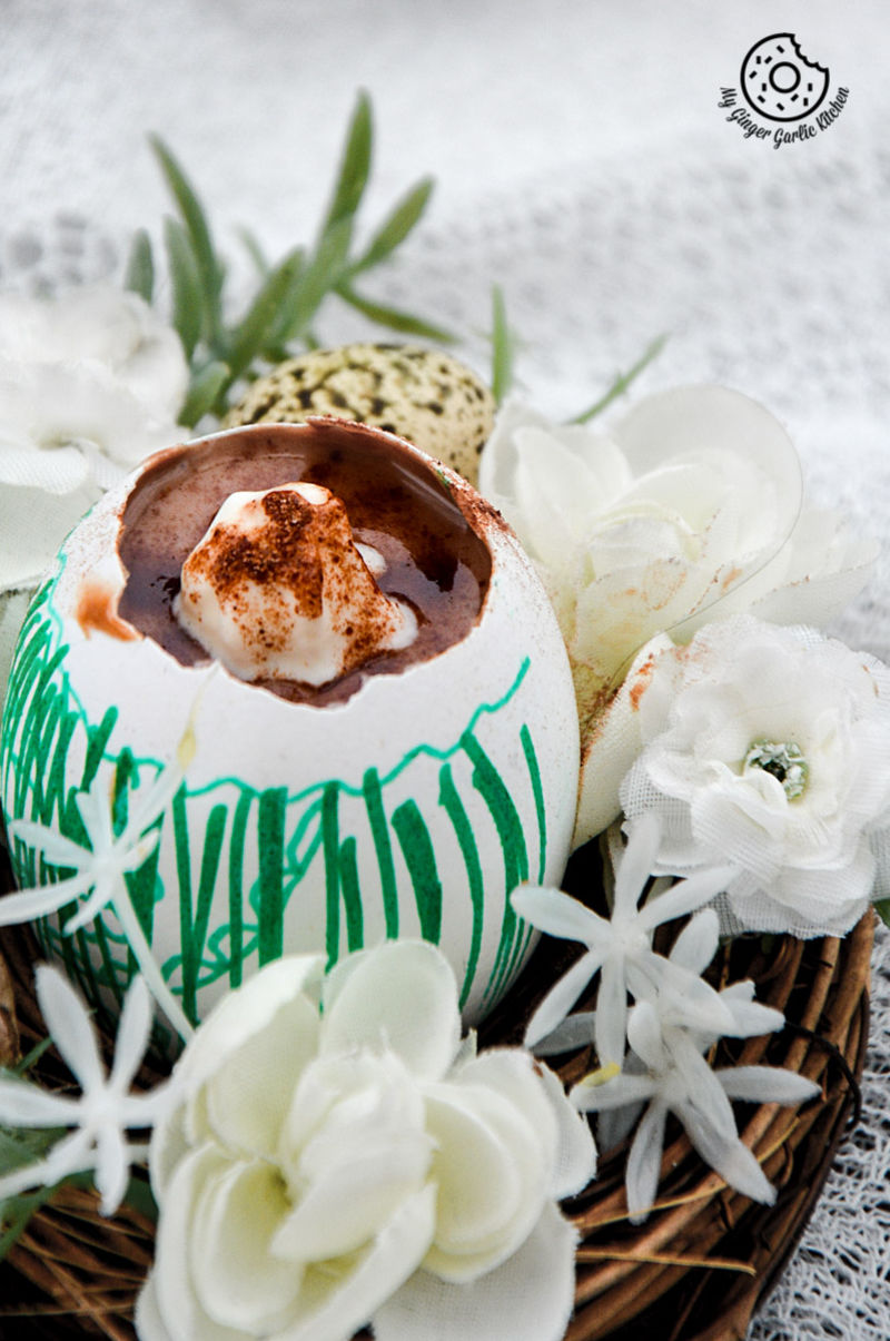 there is a bowl of chocolate lassi egg cup with flowers on the table
