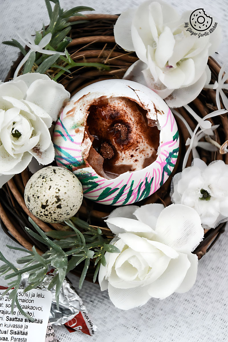 there is a chocolate lassi egg cup with a bird's nest and flowers