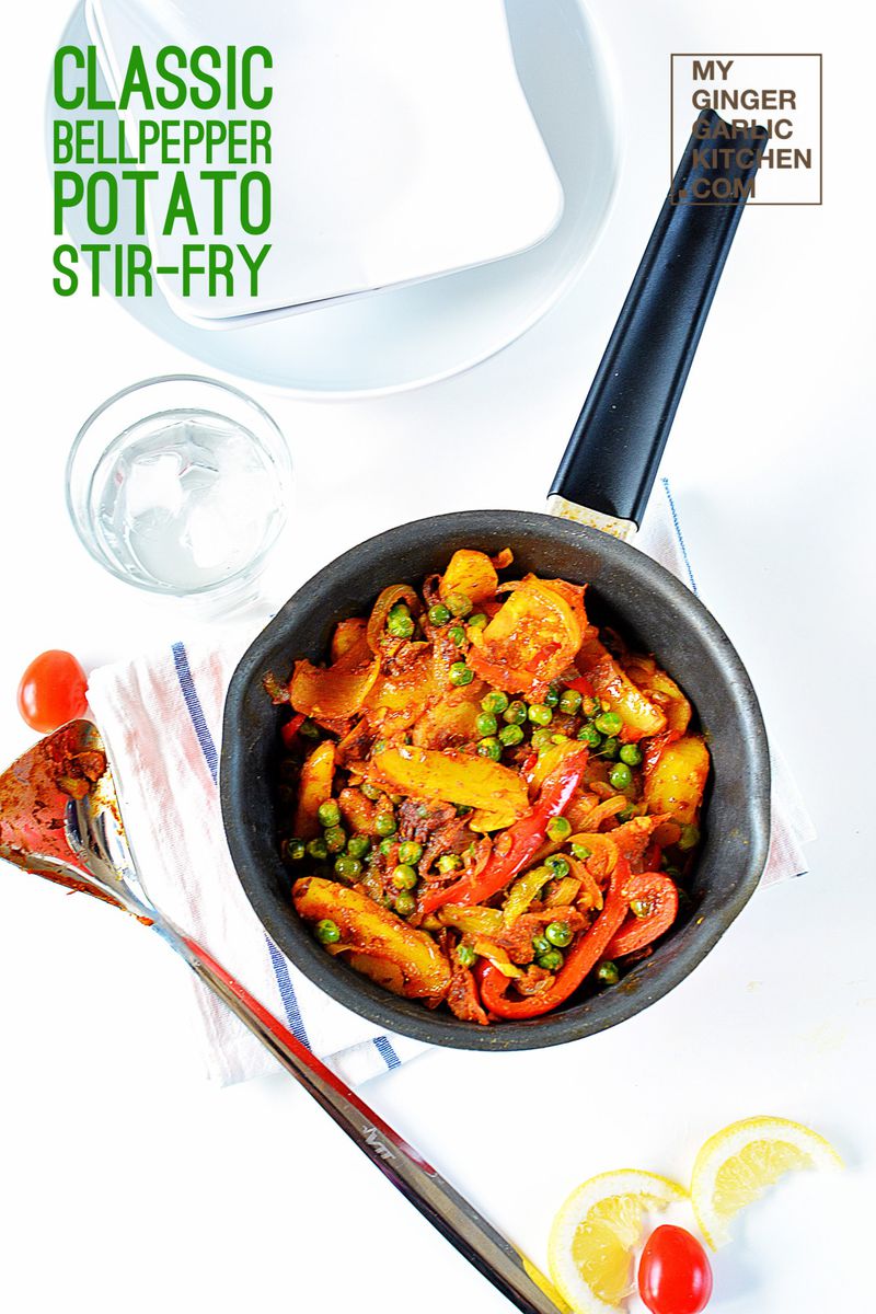 a pan with bell pepper potato peas stir fry in it on a table