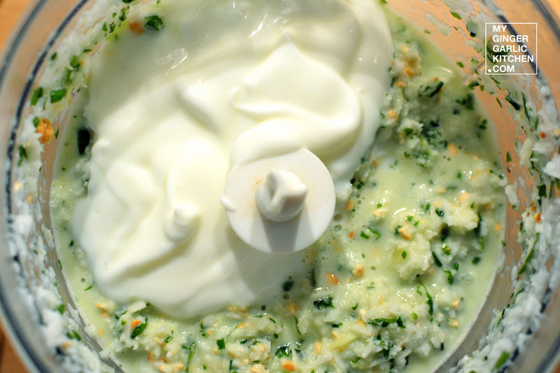 food processor with yogurt and herbs in it