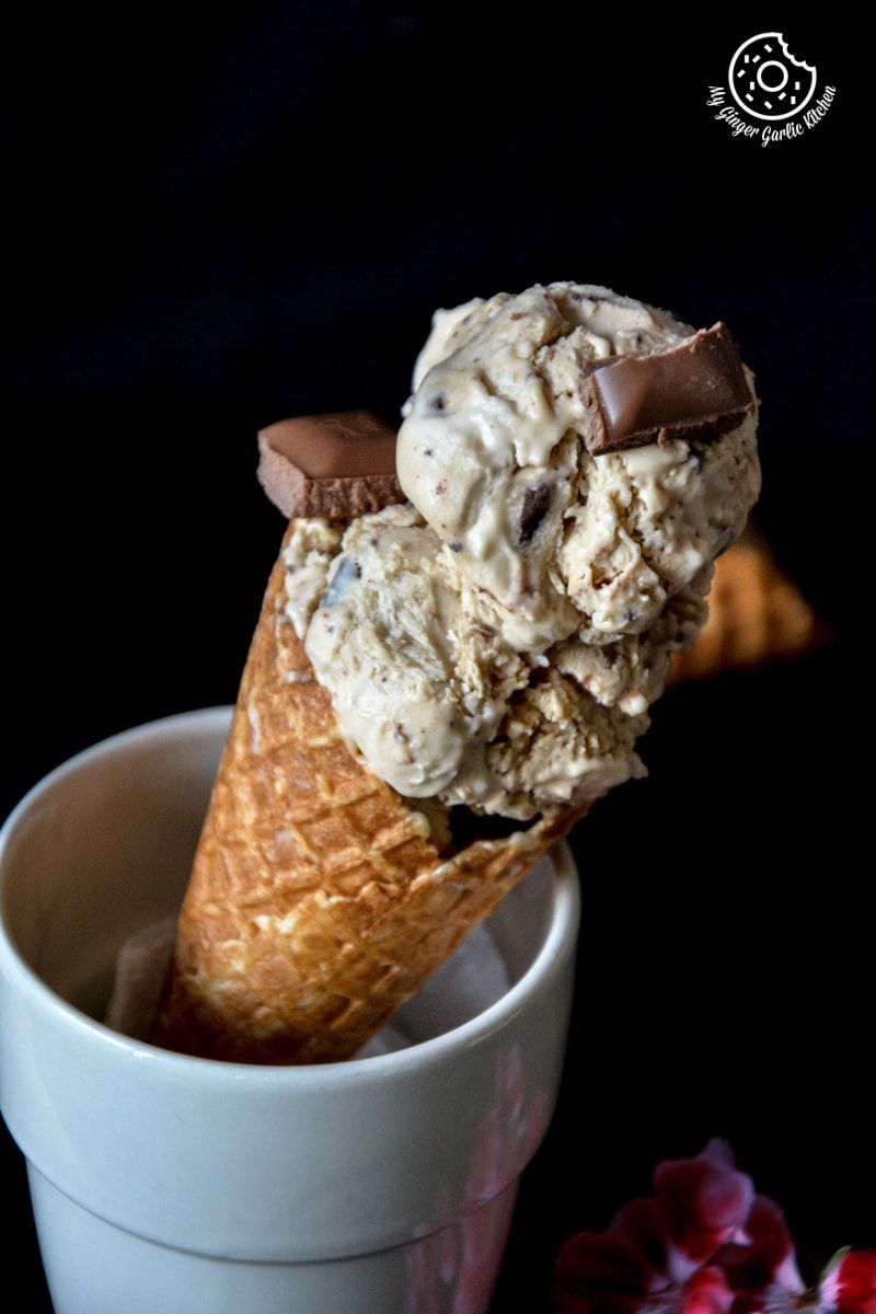 a cone of creamy coconut coffee chocolate chunk ice cream with chocolate in it