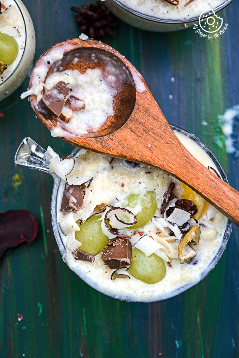 a creamy fruit and nut couscous paneer pudding with chocolate with a spoonful of pudding on it