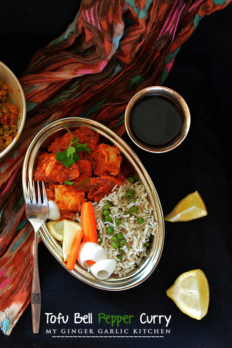a bowl of creamy tofu bell pepper curry with matar pulao and a fork