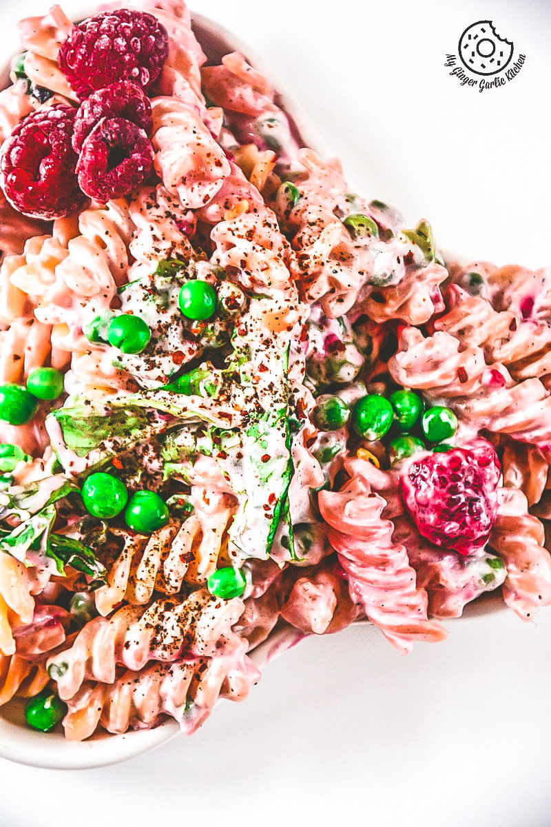 a plate of creme fraiche raspberry peas pasta with peas and raspberries on it