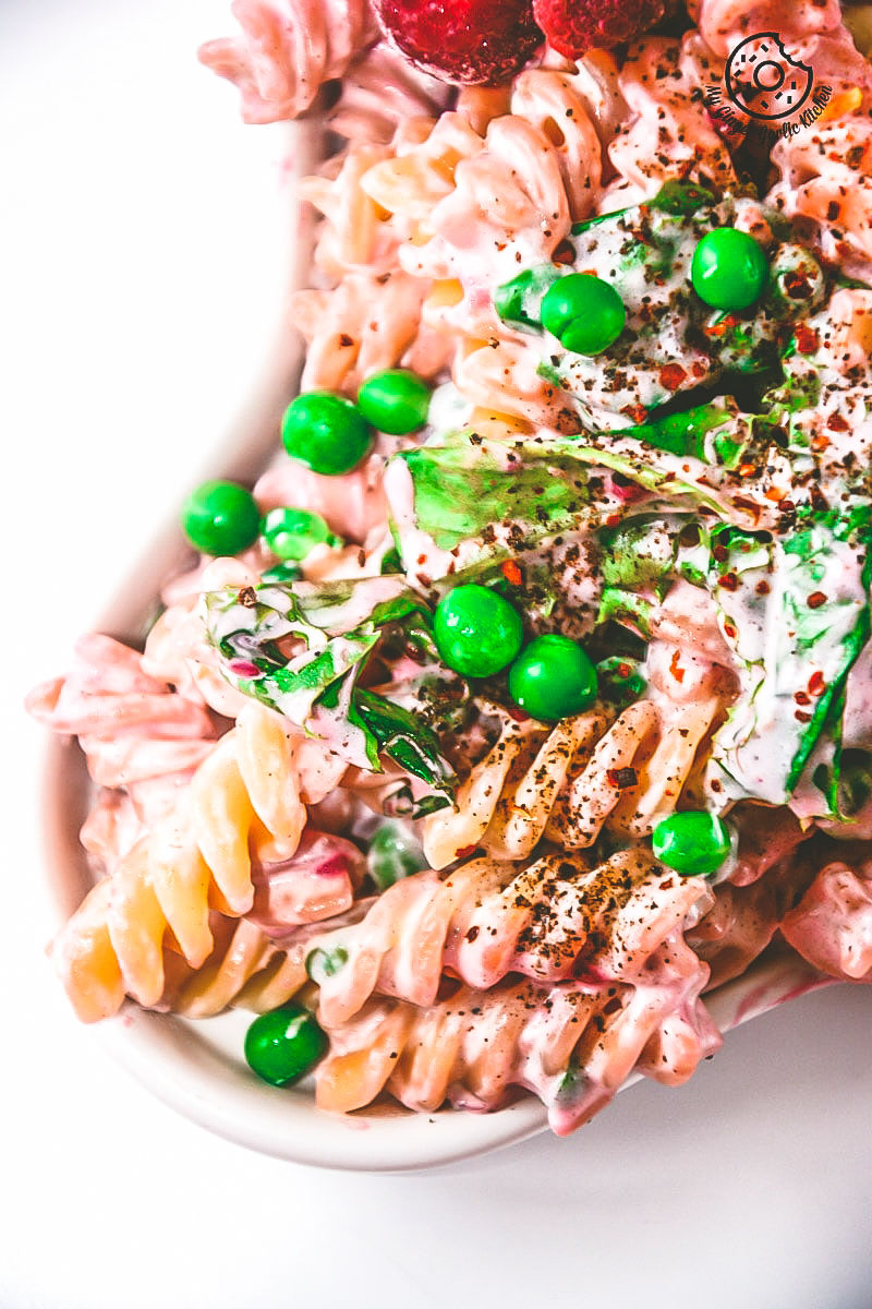 a close up of a bowl of creme fraiche raspberry peas pasta with peas and other vegetables