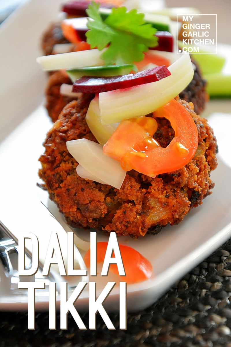 a plate with dalia tikkis and vegetables on it