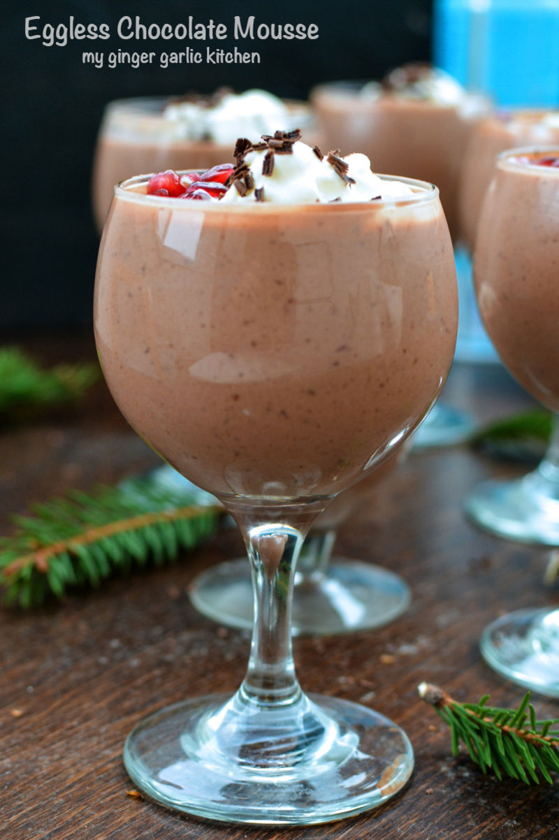three glasses of eggless chocolate mousse with whipped cream and pomegranates