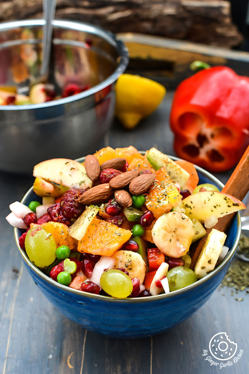 a bowl of fruits and vegetable fiesta salad with a spoon in it