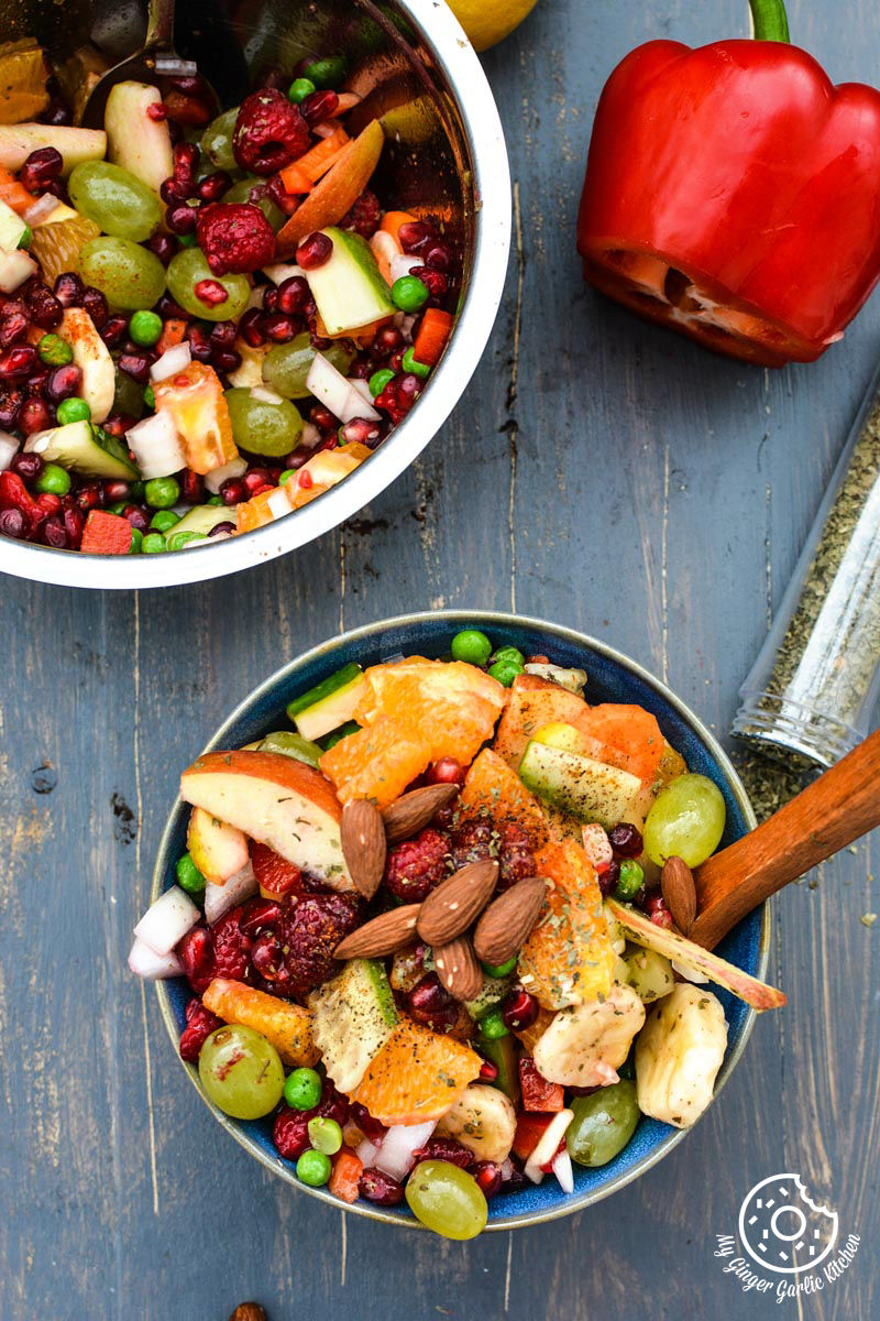 two bowls of fruits and vegetable fiesta salad on a table with red bell pepper