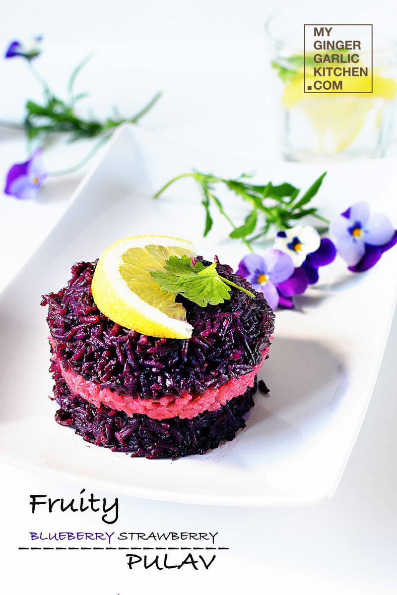 a plate of fruity blueberry strawberry pulao with a lemon slice on top