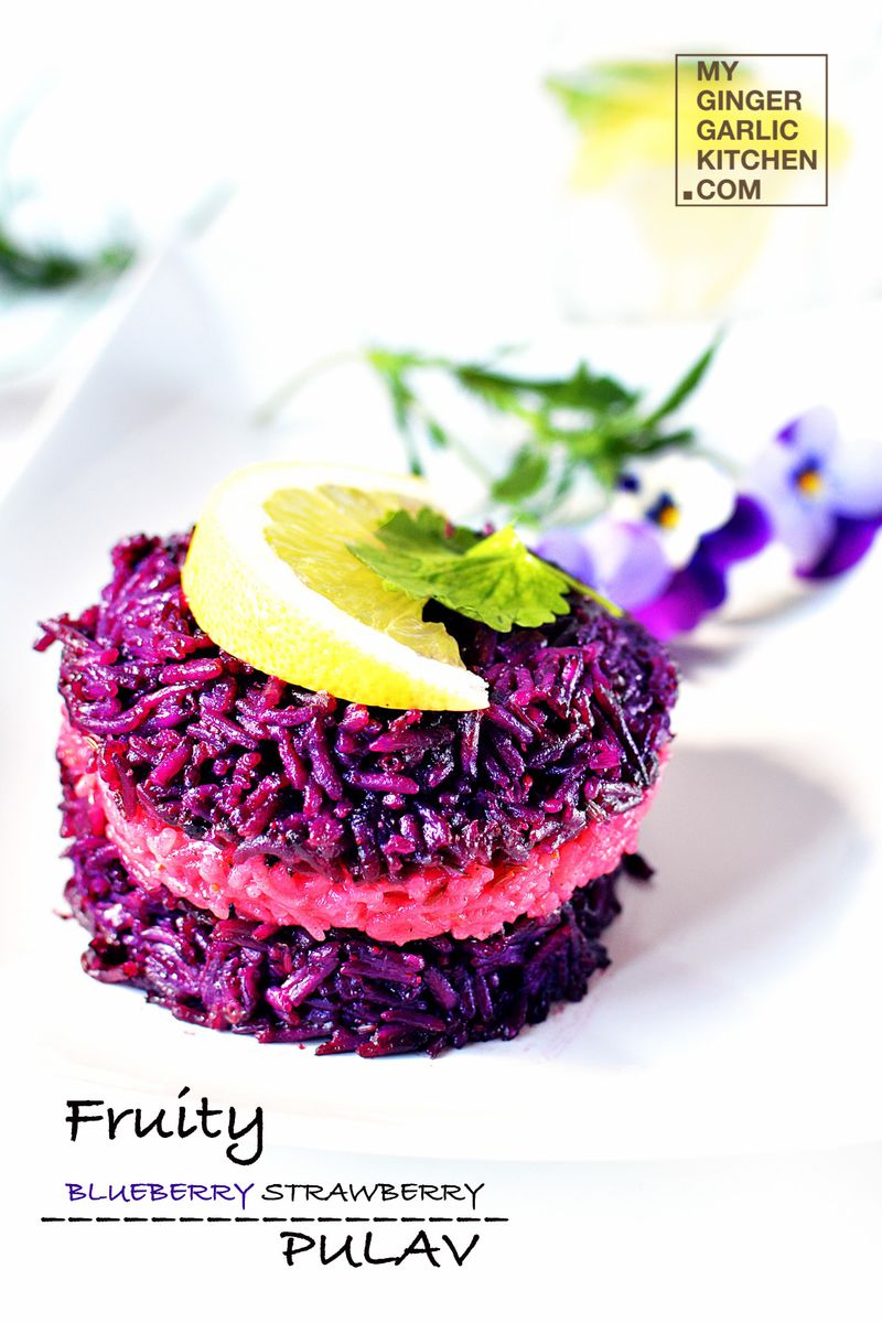 a plate of fruity blueberry strawberry pulav with a lemon slice on top