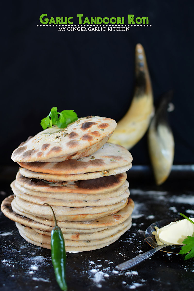 a lot of garlic tandoori rotis stacked on top of each other