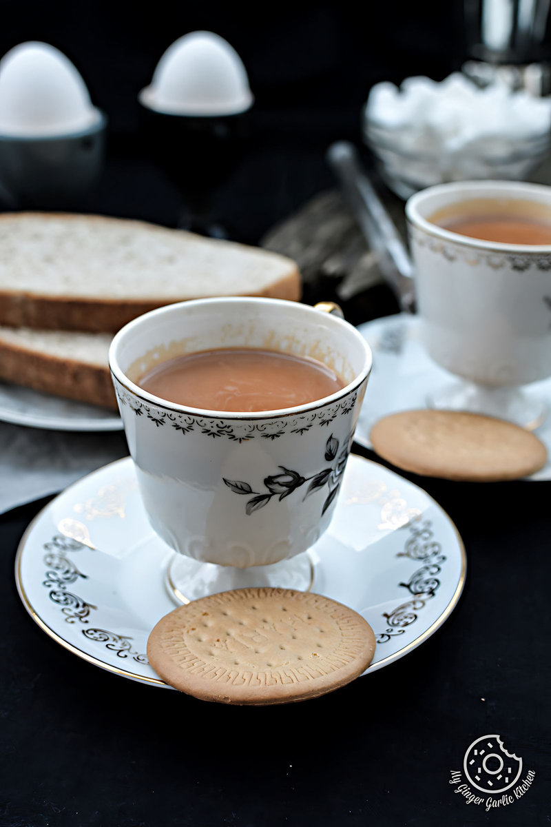 two cups of ginger cardamom tea or adrak ilaichi chai and a plate of cookies