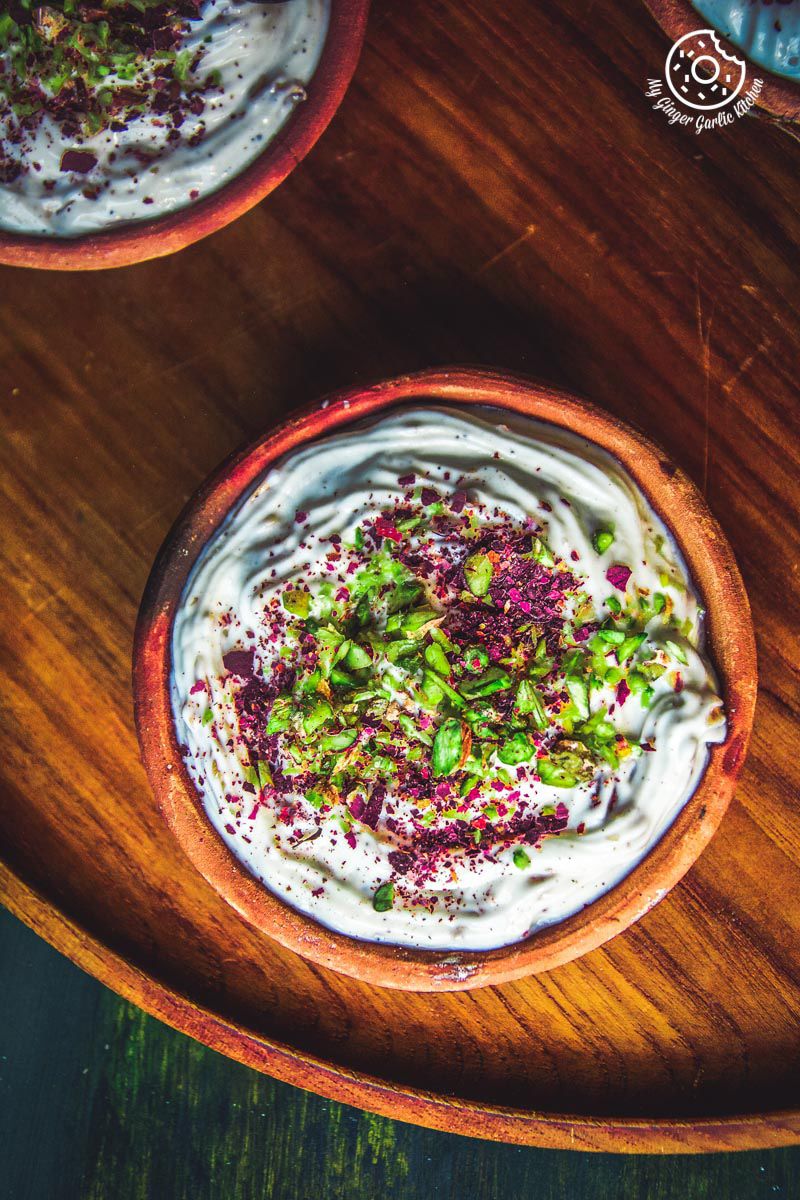 two bowls of gulkand shrikhand aka rose shrikhand on a wooden plate