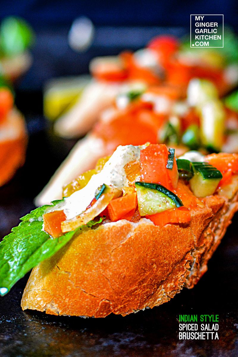 a piece of indian style spiced salad bruschetta with vegetables on it