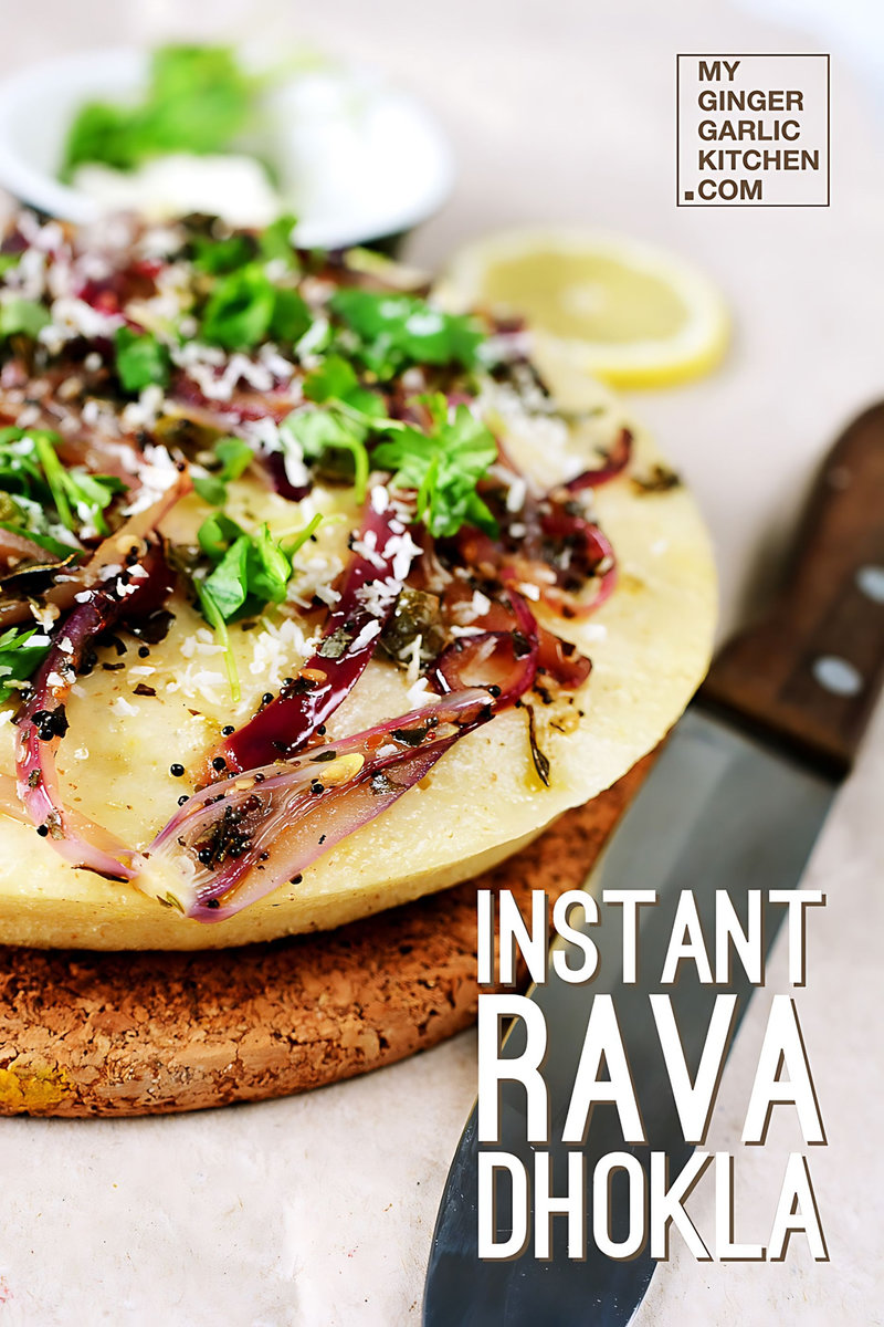 instant rava dhokla with onions and greens on it on a cutting board