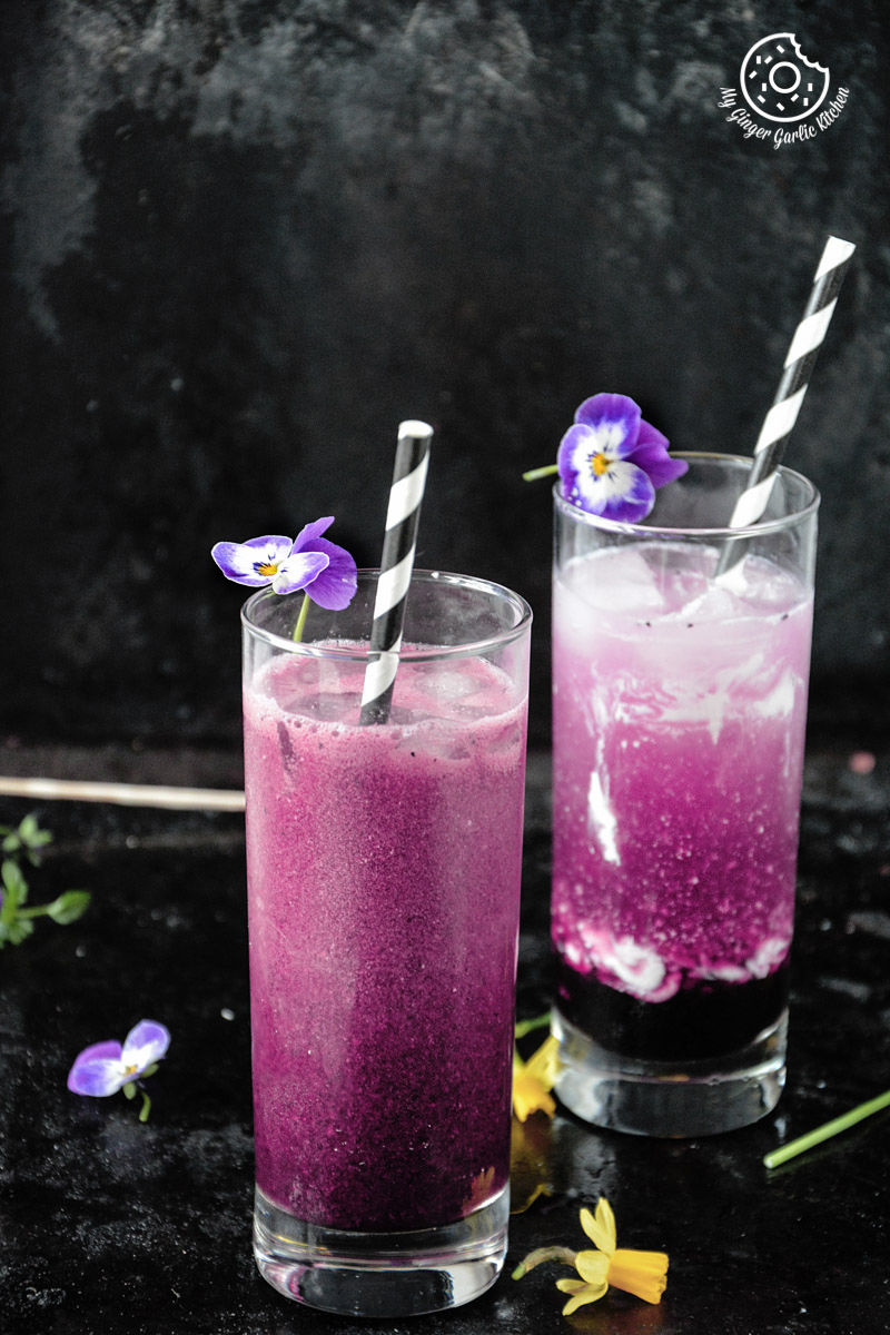 italian cream soda drink with a straw and purple flowers in a glass