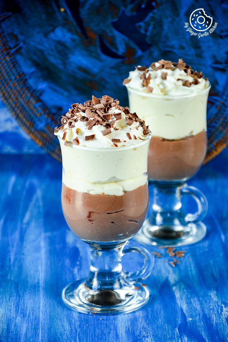 two mascarpone cream cheese chocolate mousse in small glasses on a blue table