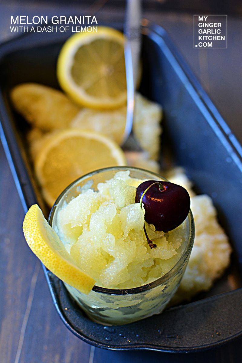 a small bowl of melon granita with a cheery and lemon on a container with more melon granita