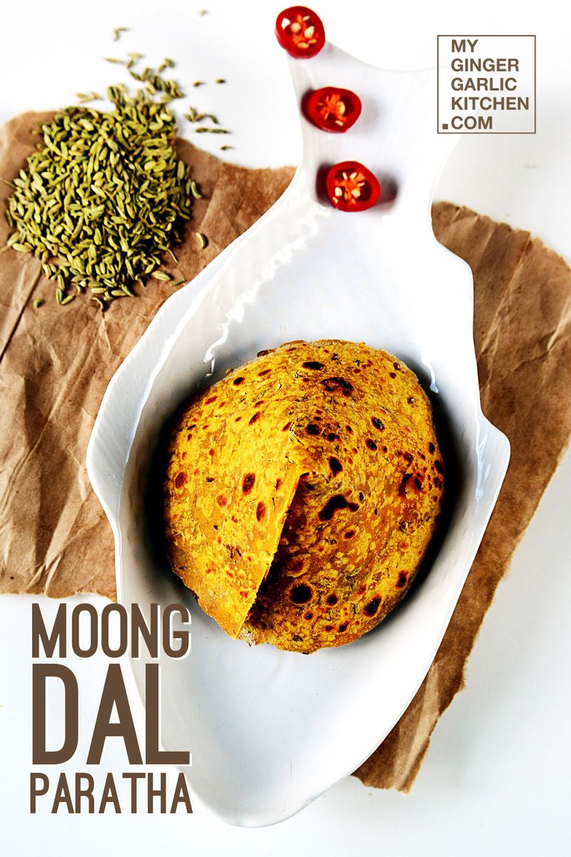 a plate of moong dal paratha with some fennel seeds on side