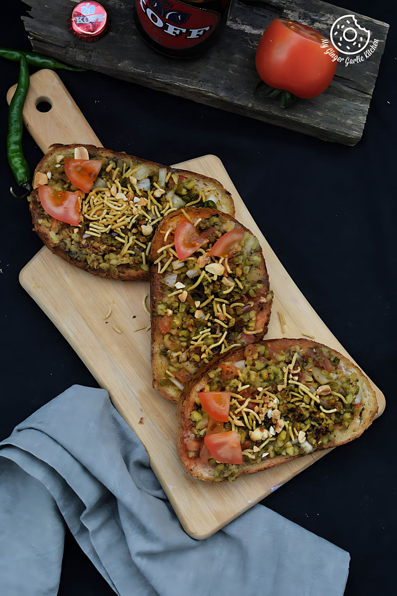 two slices of moong dal toast with toppings on a cutting board
